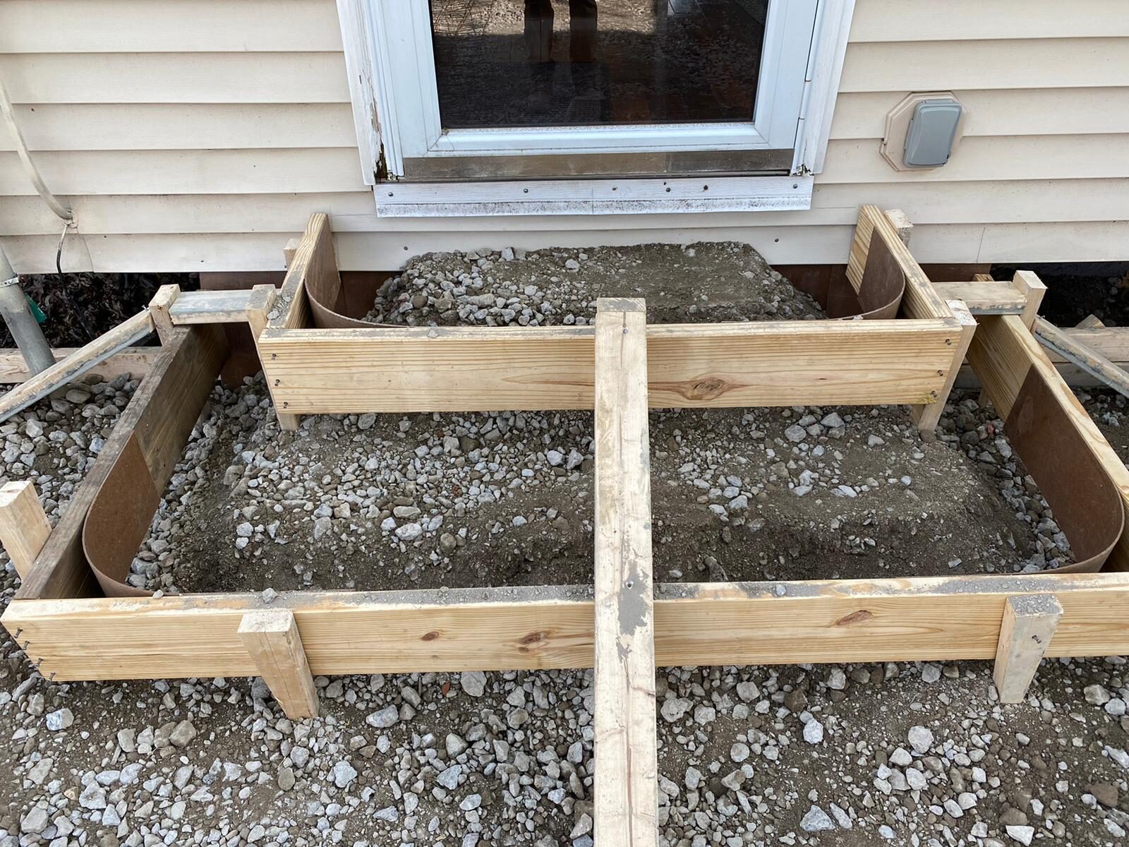 Formwork and gravel sub-base prep for a patio pour